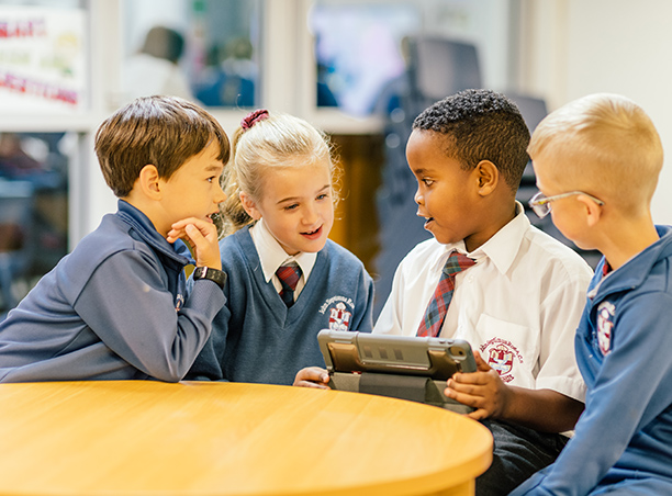 BYOD Programme, pictured is 4 children using an iPad for educational purposes.
